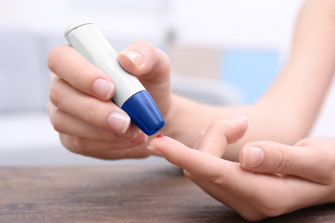 A Woman Using a Lancet Device
