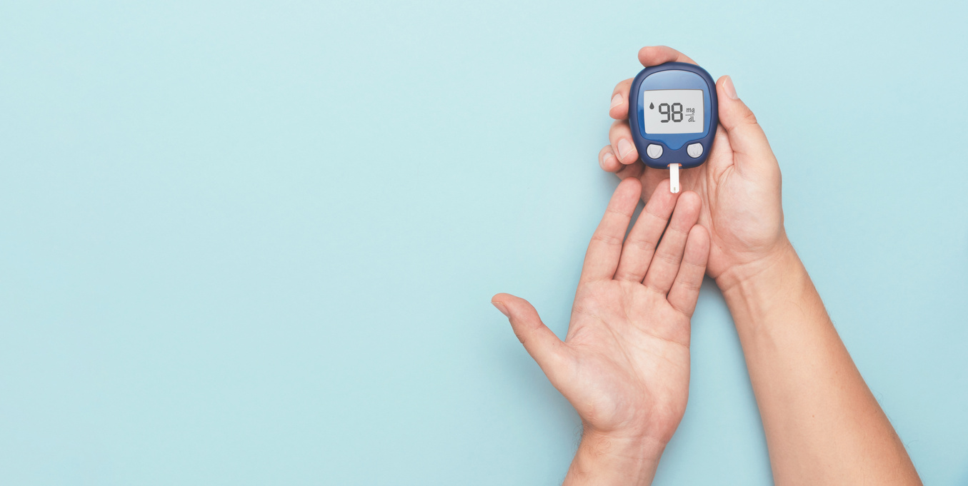 Man Using Glucometer Checking Blood Sugar Level